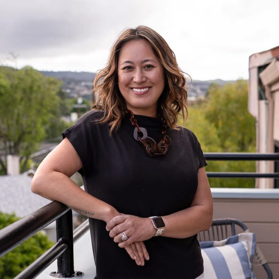 Erica Labson Aller on a balcony with greenery behind her
